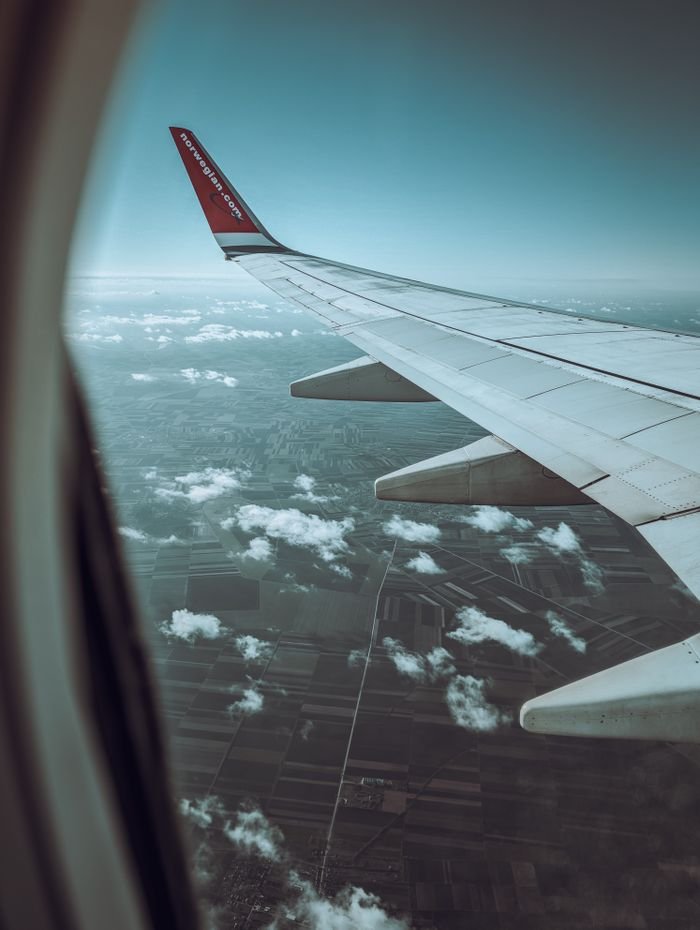 Scenic view of Belgrade's landscape through an airplane window, capturing clouds and wing.